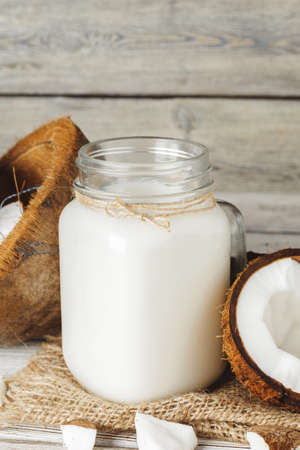Coconut and coconut milk on rustic wooden tableの写真素材