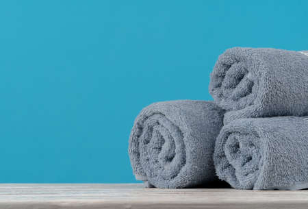 Stack of rolled towels on a wooden tableの写真素材