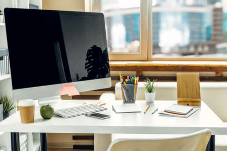 Office or home workspace. Computer monitor with black screen on office table with supplies