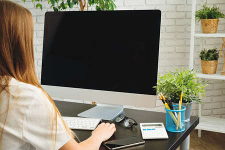 Businesswoman using her computer at an office or at home
