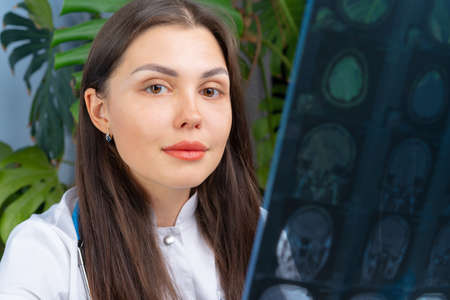 Woman doctor examining patients MR image in her officeの写真素材