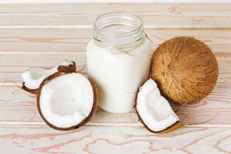 Coconut and glass of coconut milk on wooden backgroundの写真素材