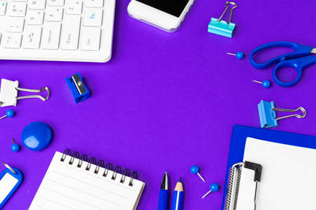 Composition of office lifestyle items on purple background, computer keyboard office supplies on desk in officeの写真素材