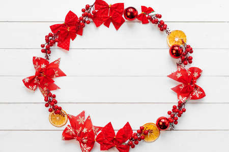 Christmas banner. Circle made of christmas decor pieces on a white wooden backgroundの写真素材