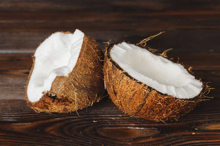 Cracked coconut pieces on dark wooden backgroundの写真素材