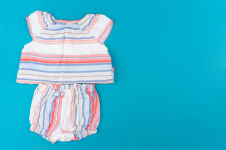 baby clothes on blue background top viewの写真素材