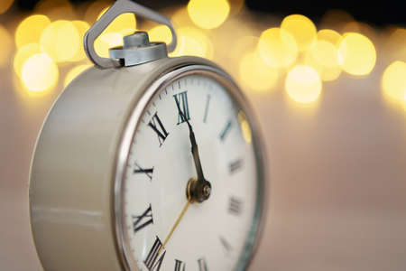 Close up of retro alarm clock on blurred Christmas background with bokehの写真素材