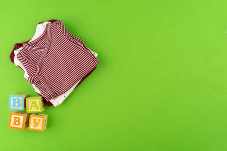 Top view of baby clothes on green backgroundの写真素材
