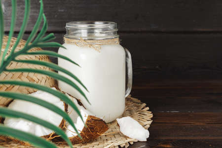 Coconut and glass jug with coconut milkの写真素材