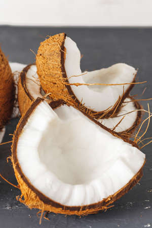 Pile of broken coconuts on ripped grey background
