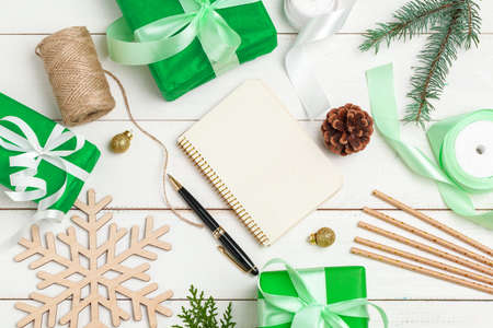 Writing christmas greeting cards. Open notepad with pen on decorated wooden tableの写真素材