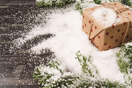 Christmas gift on wooden table powdered with snowの写真素材