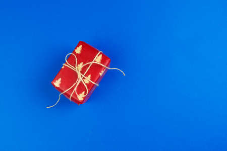 Flat lay of gift box decorated with bow on blue backgroundの写真素材