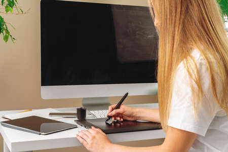 Woman designer working in office and using a graphic tablet