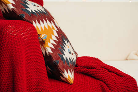 White sofa with plaid and cusion close up shot