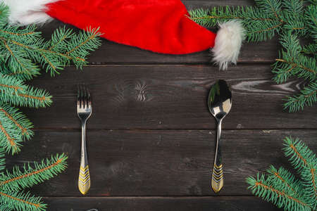 Festive table setting with pine tree branches on wooden background