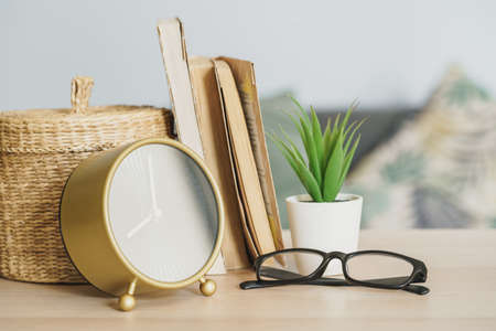 Alarm clock and office stationery objects close up on wooden tableの写真素材