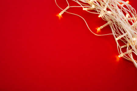 Red background with illuminated lights of garland