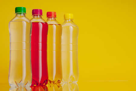 Plastic bottle full of drink on a bright yellow backgroundの写真素材