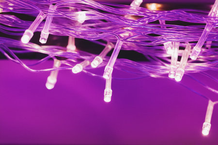 Illuminated garland lights on bright pink backgroundの写真素材