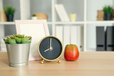 Its time for school. Vintage alarm clock and apple on wooden deskの写真素材