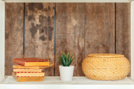 Stylish white bookshelf against grunge wooden wallの写真素材