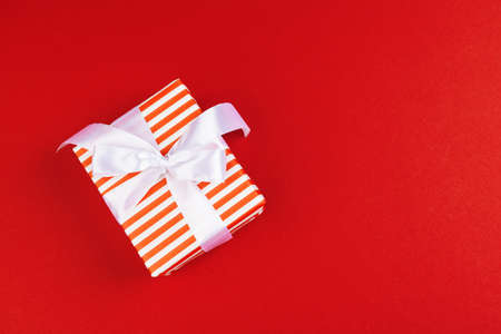 Wrapped gift box on a red background, view from aboveの写真素材