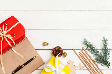 Writing christmas greeting cards. Open notepad with pen on decorated wooden tableの写真素材