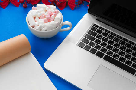 Open notepad and computer on table with christmas decorの写真素材