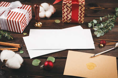 Empty letter with a feather on old wooden background decorated with christmas objectsの写真素材