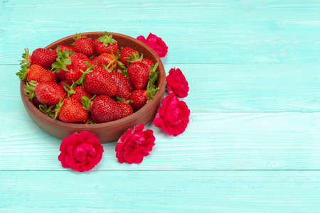 Bowl of strawberry harvest on wooden table close upの写真素材