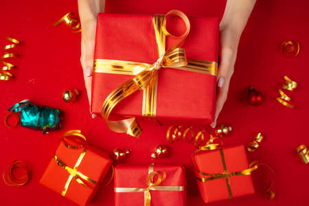 Female hands holding present on a red backgroundの写真素材