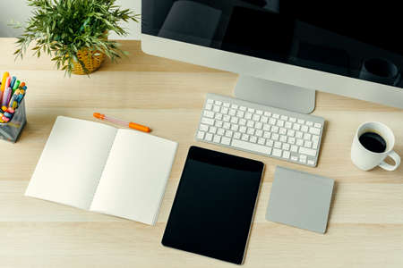 Top view of working table with computer, notepad, coffee cup and suppliesの写真素材