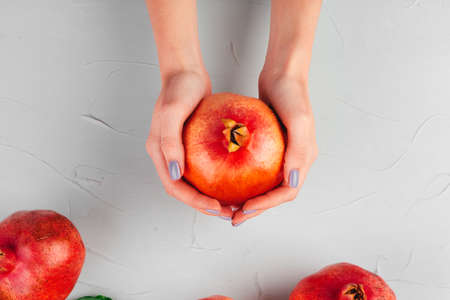 Ripe pomegranates on a light gray kitchen tableの写真素材