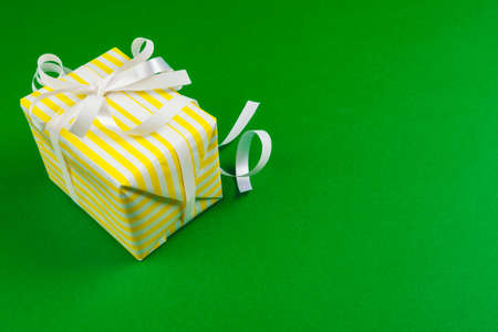 Decorated gift box on a green background, flat lay top viewの写真素材