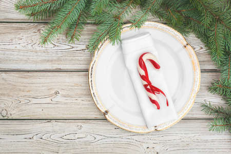 Wooden table with pine tree branches and holiday table settingの写真素材