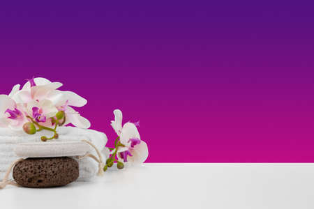 Beautiful pink flowers and white towels on pink backgroundの写真素材