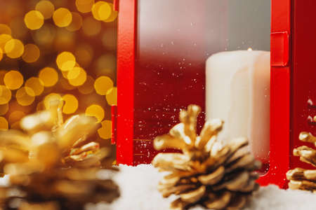 Christmas red lantern with burning candle on wooden tableの写真素材