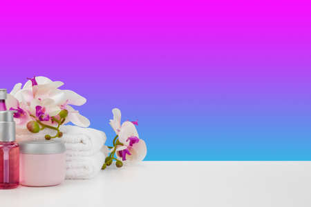 Beautiful pink flowers and white towels on pink backgroundの写真素材