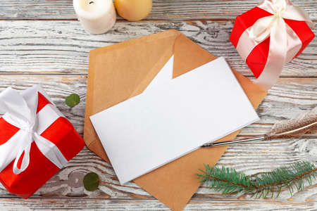 Close up of Christmas letter writing on yellow paper on wooden background with decorationsの写真素材