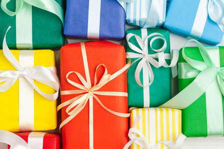 Many colorful gift boxes with ribbons backgroundの写真素材