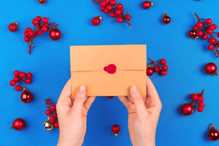 Desk with envelope and Christmas decorations. Flat lay. Mockup