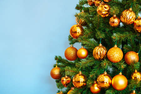 Christmas tree with golden baubles close up on blue backgroundの写真素材