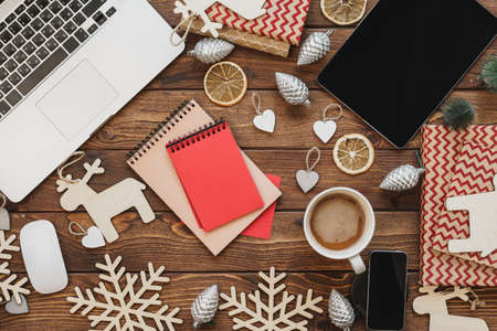Top view of a wooden desktop with computer with office supplies and Christmas decorationsの写真素材