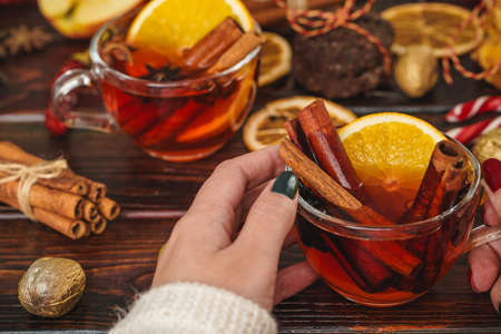 Woman holding cup with mulled wine in her hands