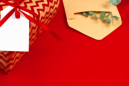 Craft christmas gifts with red ribbons on decorated christmas backgroundの写真素材