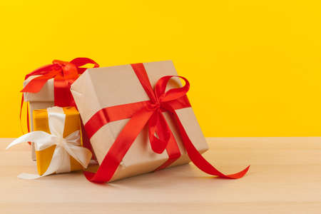 Gifts with ribbons on bright yellow background