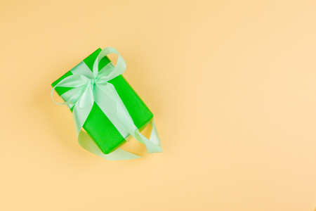 Decorated colored present on yellow background flatlayの写真素材