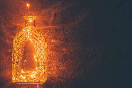 Lights garland in a glass bottle on a dark backgroundの写真素材