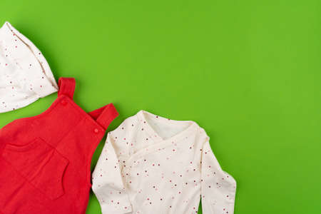 Top view of baby clothes on green backgroundの写真素材